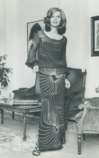 Margo Lane, television personality, will wear a pencil slim skirt of chocolate brown sheer splashed with bright colored sunbursts and matching top to greet the New Year
