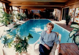 Can't swim: Marilyn Lastman reaxes amid the luxuriant foliage of the indoor pool area of her 16-room home.