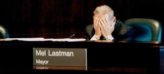 Taking cover: Mayor Mel Lastman has a rough time at council yesterday trying to sell his phase-in plan for property tax hikes and cuts.