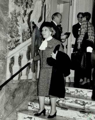 Estee Lauder pauses on the marble steps of the Hotel Pierre where Bill Blass showed his spring line.