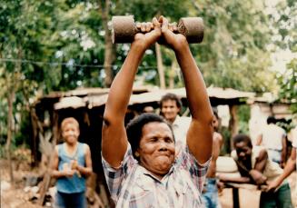 Manny Lee's mother Ana Carolina Lee, showing how many use to train with home made weights from concrete, at San Pedro.