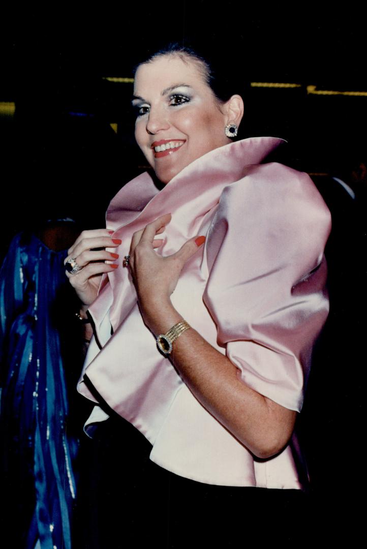 Co-chair of the Opera Ball Catherine Leggett, above, wears an eye-catching pastel pink satin jacket with high collar and puffed sleeves over a slim black velvet strapless gown
