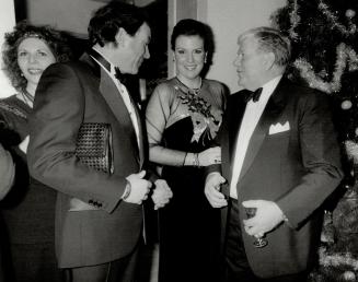 Above Catherine Leggett, wearing an Oscar de la Renta gown, chats with escort David Nugent, left, and John Combs.