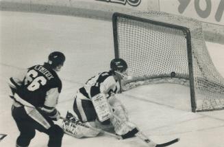 First of three: Mario Lemieux and Ken Wregget watch as Lemieux's 34th goal of season sails into net. Lemieux had hat trick and two assists in game.