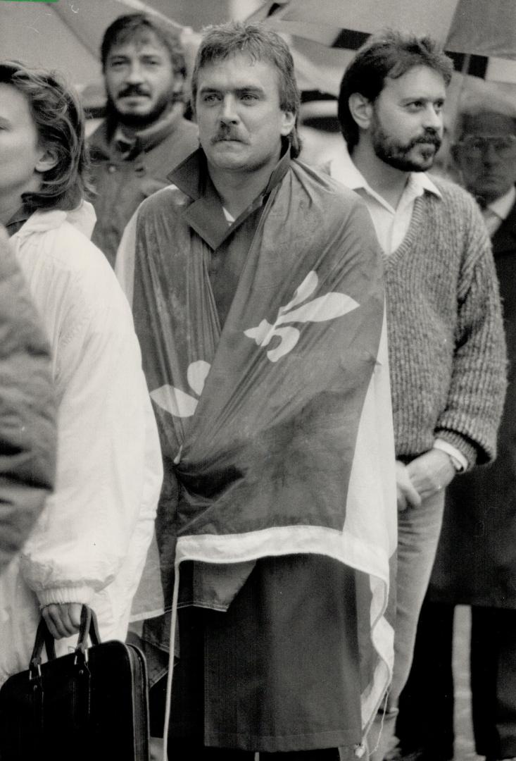 His last respects: A mourner draped in the Quebec fleur de lis flag was among the thousands of Montreal-area people who lined up yesterday to say farewell to former premier Rene Levesque
