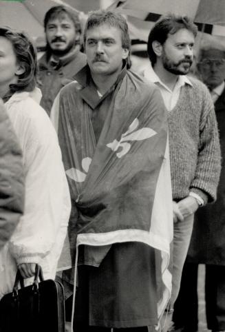 His last respects: A mourner draped in the Quebec fleur de lis flag was among the thousands of Montreal-area people who lined up yesterday to say farewell to former premier Rene Levesque