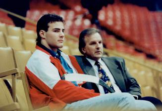 Courted by leafs? Eric Lindros, left, watches Leaf practice yesterday with Bill Watters, Leaf assistant GM