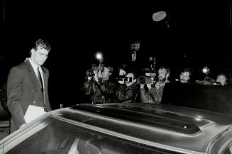 Press gang: Newspaper and television photographers form a line to get shots of Eric Lindros as he leaves his assault trial yesterday in Oshawa