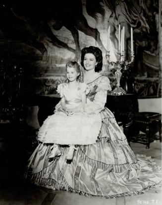 England's contribution to this trio of beauties is the Eagle Lion screen actresss, Margaret Lockwood, seen here holding her daughter on her knee, a difficult thing to do, considering her immense hoop skirt