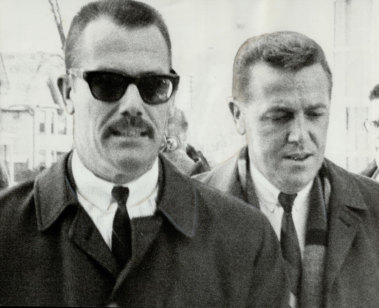 Peter Lott (left) is led into the police staff house on Charles St