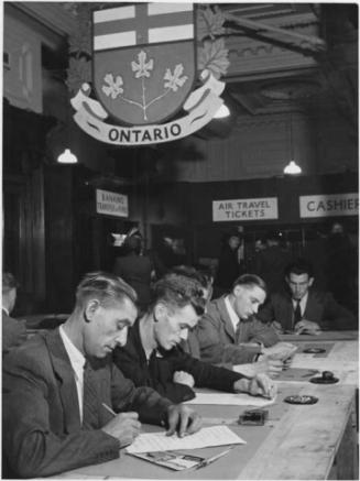 British emigrants filling out forms to travel to Canada by air