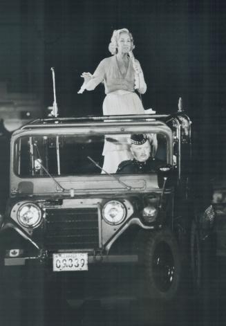 Military escort: Dame Vera Lynn sang her goodbys to the Grandstand crowd from the back of a military Jeep last night