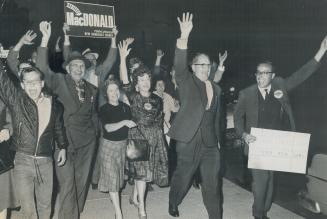 March of triumph: Surrounded by his jubilant supporters, New Democratic Party Leader Donald MacDonald strides through the streets toward the hall where more of the party faithful are waiting to congratulate him