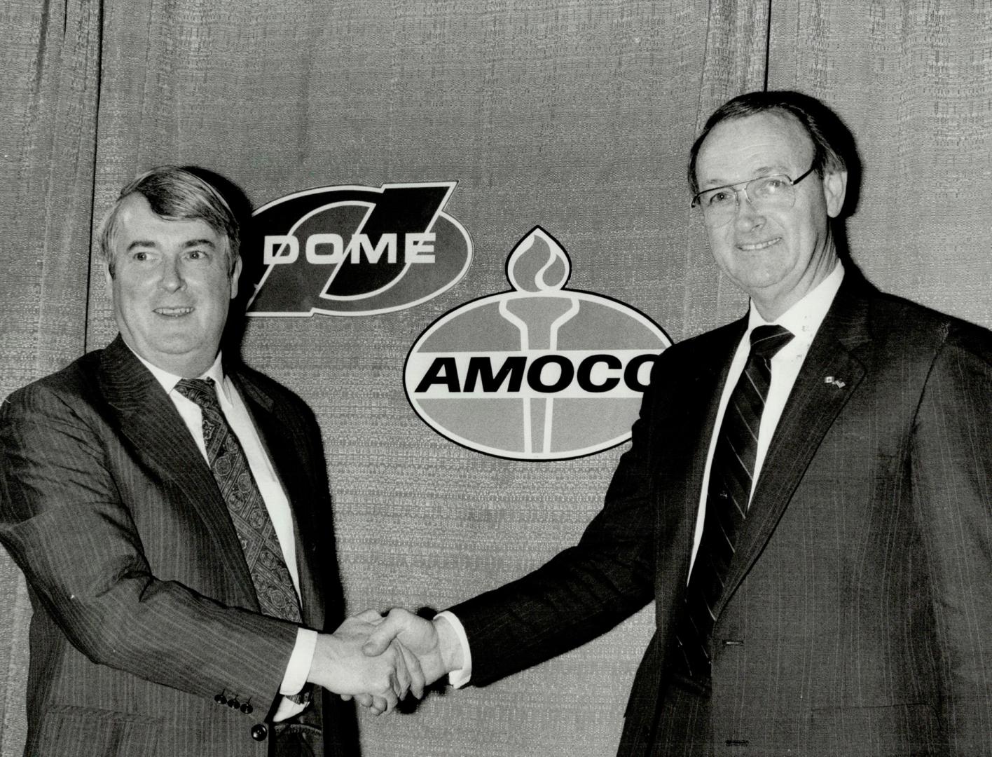 Smiles in order? Dome Pete's Howard Macdonald and Amoco Canada's Donald Stacy shake on what they hope is their deal.
