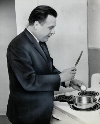 Allan MacEachen, Canada's minister of health, fries up some eggs in his bachelor apartment in Ottawa