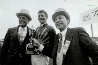 Triumphant Trio: Trainer Roger Attfield, left, jockey Craig Perret and owner Earle Mack flash winning smiles yesterday after Peteski romped to a dominating Queen's Plate win yesterday at Woodbine