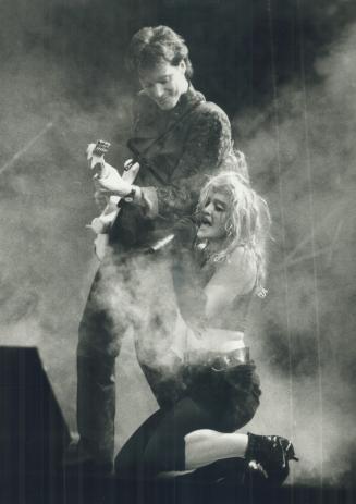 Naughty but nice: Madonna flaunted her sexuality at the feet of one of her guitar players and before 18,000 screaming mini-Madonnas at Maple Leaf Gardens last night