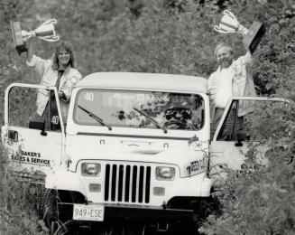 In time to win: Barbara Mahler and husband John - whose day job is photographer for The Star and who is also Wheels' regular tire tester - hold aloft the trophies they bagged after surviving a day-long rally in the Jeep Cup finale