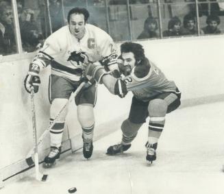 Big M stopped: Frank Mahovlich of Toronto Toros is pushed against boards by defenceman Brent Hughes of San Diego Mariners during World Hockey Association game at the Gardens last night