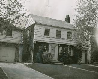 Image shows a two storey residential house with a garage on the left side.