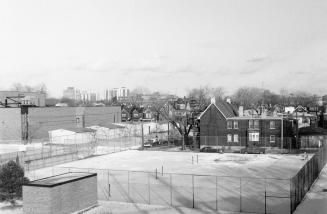 Looking northeast from Dundas Street West bridge and Canadian Pacific Railway tracks, Toronto, Ont, showing house at the southeast corner of Lumbervale Avenue and St. Helens Avenue on right and West Toronto Secondary School on left.