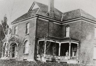 Woman on the porch of Dr. Opie Sisley's home, now Ogden Funeral Home. Agincourt, Ontario