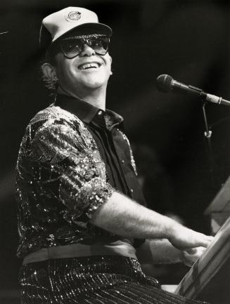 Rain didn't stop him: Elton John, wearing a Blue Jays cap, may not have had a major hit for a while but he gave CNE grandstand's 25,000 fans a show to remember Tuesday night
