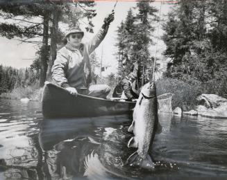Algonquin Park, Ontario, fisherman Wayne Cowling pulls speckled trout and former footballer Bill Symons is ready with net