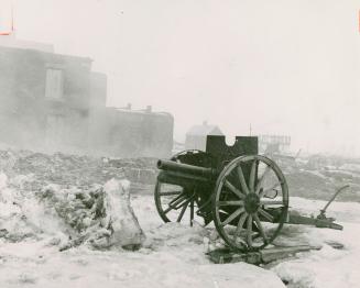War memorial cannon stands in smoke of burning buildings being demolished for seaway at Morrisburg