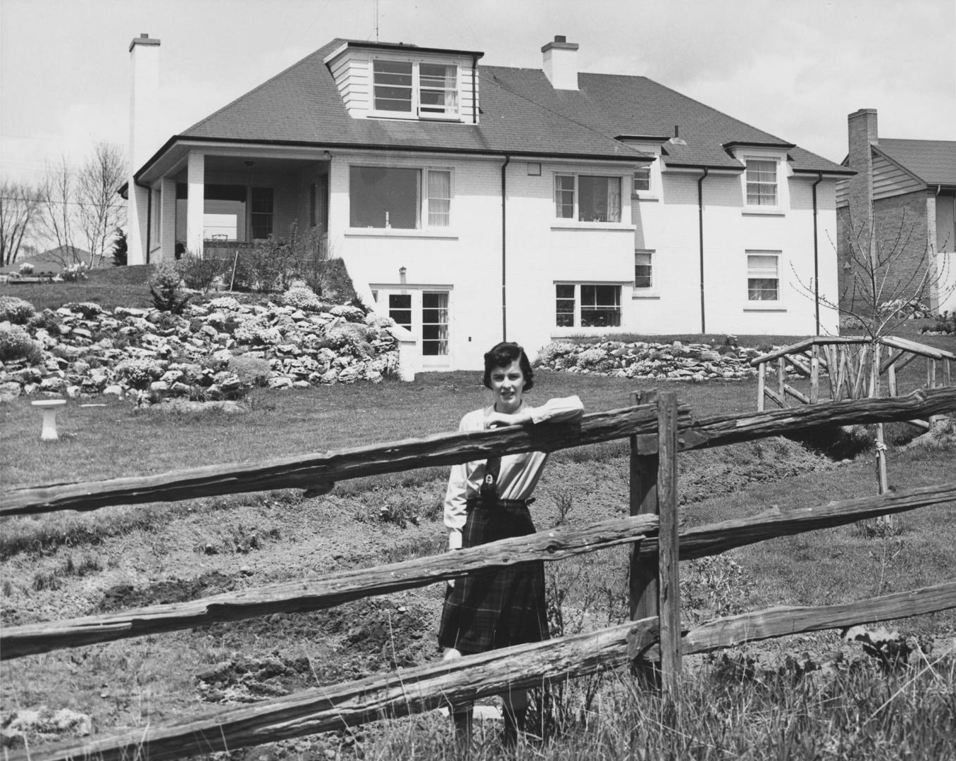 Woman posing in front of a house, Bayview Village, Ontario