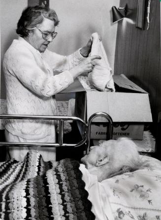 Mary Love, director of the Armstrong Nursing Home, is packing patients' belongings in preparation to move. Bolton, Ontario