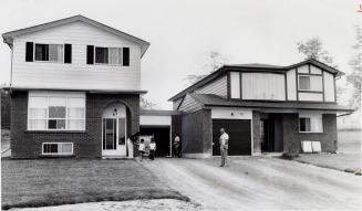 Elevated bungalow and two-storey house joined by a common garage wall in Camelot Village. Bowmanville, Ontario