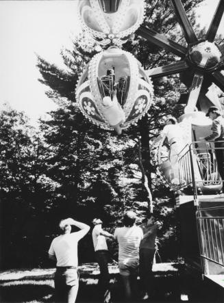 Three men link arms to form human net for Hilda McConnell, who was dangling by one foot from ferris wheel car for 10 minutes. Santa's Village, Bracebridge, Ontario