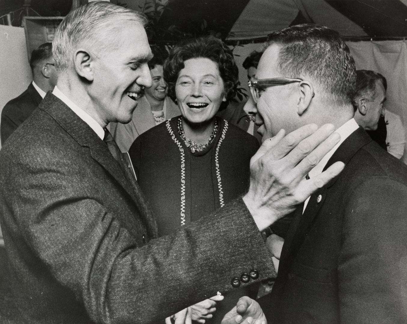 (L to R) Dalton Bales, elected PC candidate for York Mills, receives the congratulations of Jim Service, the defeated liberal cand. as Mrs. Bales looks on