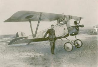 Canadian V.C. Winner, Capt. (now Air Marshal) W. A. Bishop, is shown standing beside his warplane [1917?] in which he eventually became on of the most feared pilots on the western front in World War 1. His early model is a Nieuport aircraft