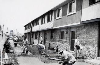 Workmen rushing to finish model townhouses at Kennedy Green. Brampton, Ontario