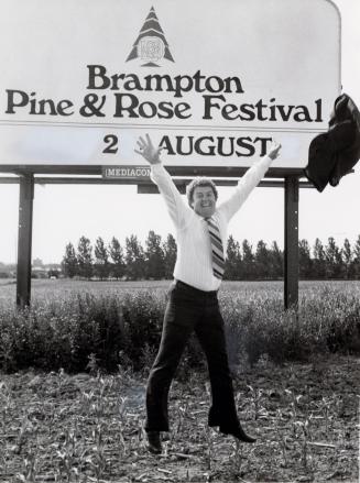 Dick Metzack, festival chairman of the Brampton Pine and Rose Festival in 1983, flings his suit jacket. Brampton, Ontario