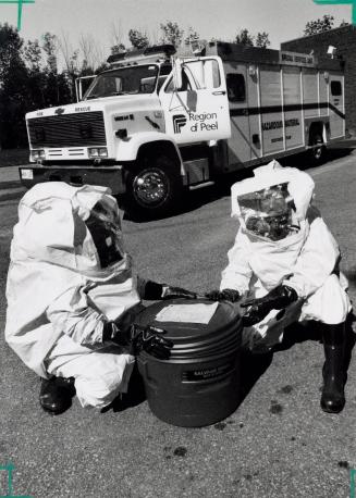 Brampton firefighters Bill Watts and Mike Prong are suited up to handle emergencies with Peel's new hazardous materials truck. Brampton, Ontario