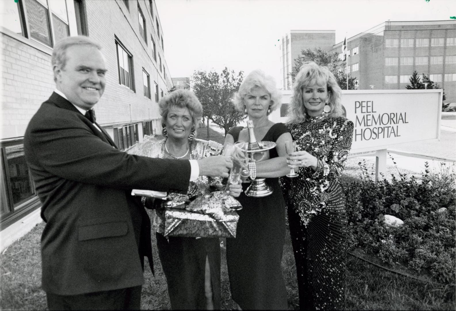 Warren Hitchcock of Goliger's Heart Lake travel agency toasts Peel Memorial Hospital Foundation members, from left, Hazel Peoples, Karen Lockwood and Louise Kidy. Peel Memorial Hospital, Brampton, Ontario