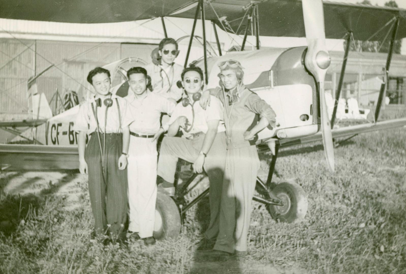 Robert Wong and Chinese student pilots pose in front of an aircraft