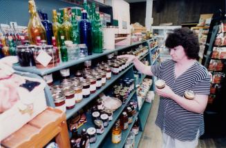 Woman shopping for jam in country store.