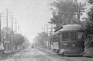 Yonge Street looking south at Sherwood Avenue. Image shows a street view with a railcar and a f ...