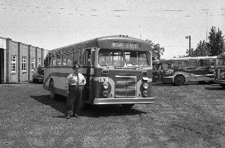 Hollinger Bus Lines, bus #62, at garage, Woodbine Avenue, southeast corner O'Connor Dr., looking east, showing bus' driver Roland Harden