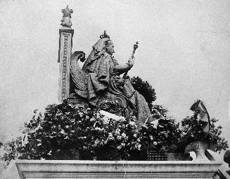 Historic photo from Saturday, May 24, 1913 - Queen Victoria statue decorated with flowers, east of entrance to Parliament Buildings, Queens Park. in Queens Park