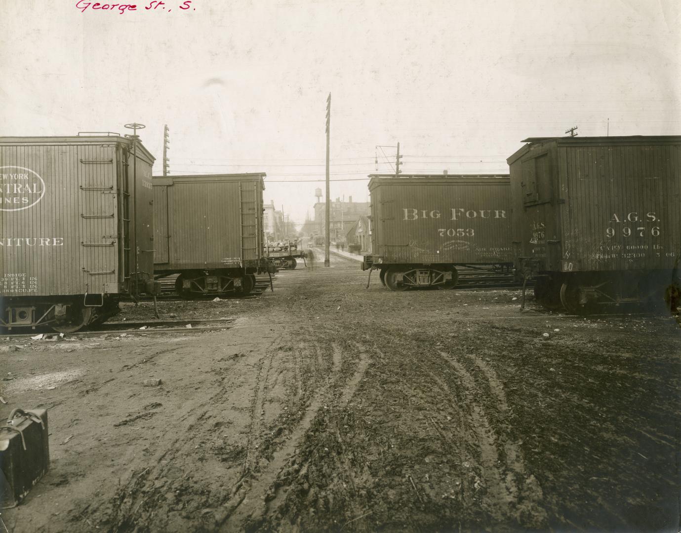 Image shows a street view with a few containers on wheels on both sides.