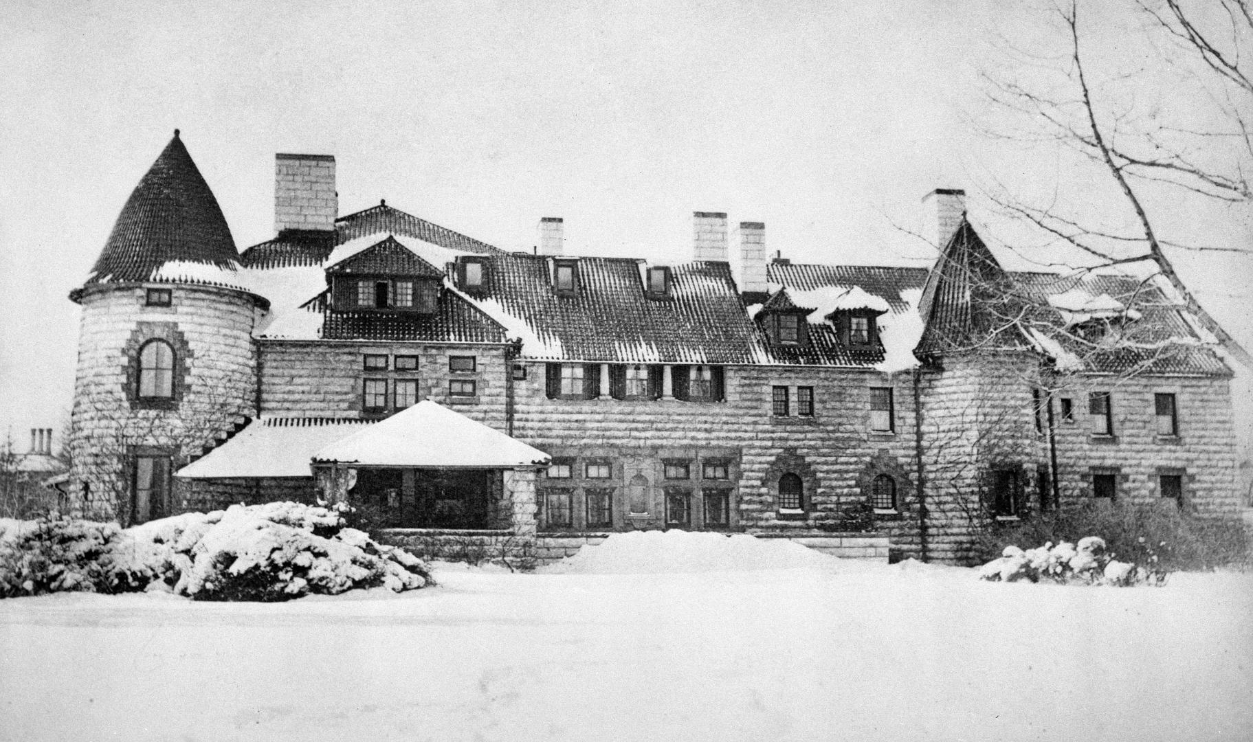 Image shows an exterior of a big three storey house in winter.