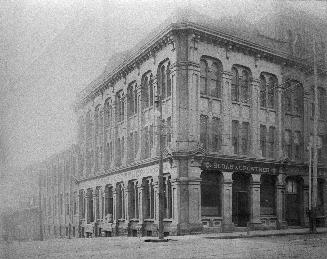 Scott St., southwest corner Front Street East, showing Sloan & Crowther, wholesale grocers, on corner and Great Western Station in background