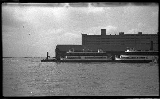 Image shows a few ferries on the lake by the docks.