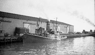 Image shows a tugboat by the wharf.