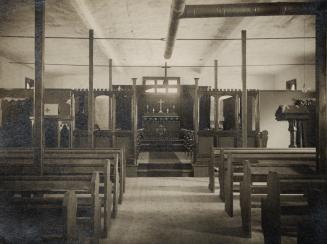 Image shows an interior of the church with the altar in the center and pews on both sides.